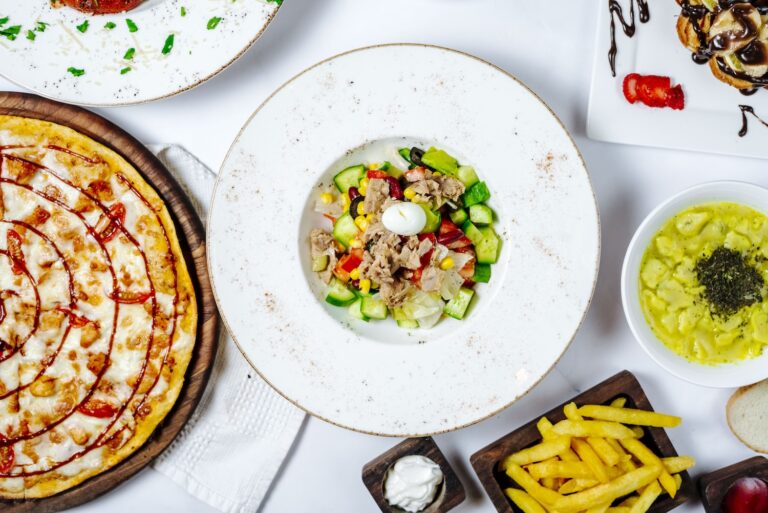 Variety of delicious dishes including pizza, salad, and fries.